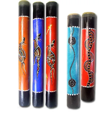 Five painted clapsticks with vibrant Aboriginal designs, including lizards and dotted patterns.