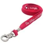 Red lanyard with metal clip and white text reading The Village at CSU Stanislaus.