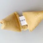 A broken fortune cookie with a slip of paper showing numbers inside.