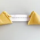 A broken fortune cookie with a slip that reads, Choose your love, love your choice.