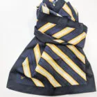 Navy blue scarf with yellow and white diagonal stripes, folded on a white surface.