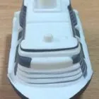 A small white and black toy ship on a wooden surface.