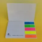 Open notepad with colored sticky tabs on a yellow background.