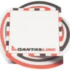 A QantasLink notepad with a red, black, and white circular checkered border design.