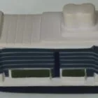 A small model of a cruise ship with black and white detailing on a light surface.