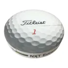 Close-up of a Titleist golf ball with its dimpled surface; Titleist is boldly written in black above the red number 1, while NXT Extreme subtly appears. Its design captures light beautifully, reminiscent of a Magic Prism Disk on the green.
