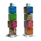 Two Revolving Cube desk calendars for 2005 feature colorful blocks with baby photos and monthly calendars, stacked on sleek white triangular bases labeled DOODT.