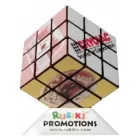 A Rubiks 3x3 Cube features promotional images on each face, mounted on a Rubiks Promotions stand with different product showcases and a website URL below.