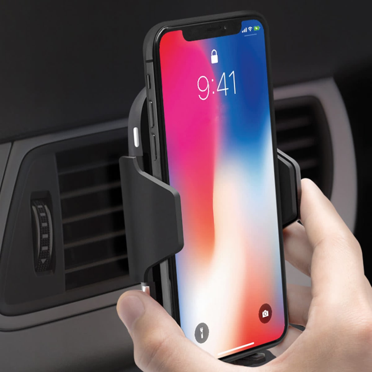 Phone mounted in a car vent holder with a colorful lock screen display.