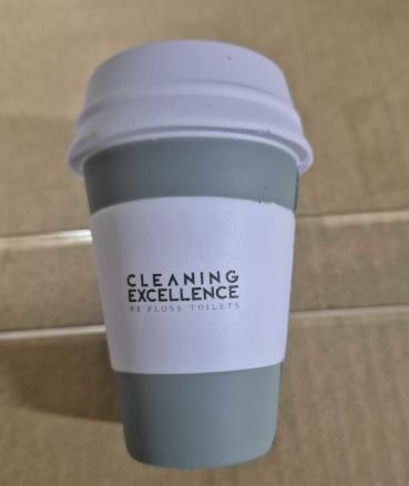 Gray reusable coffee cup with Cleaning Sydney printed on a white band, on cardboard surface.